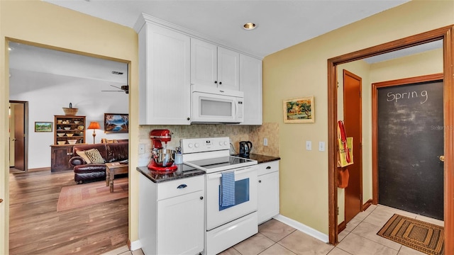 kitchen with white appliances, white cabinets, baseboards, and tasteful backsplash