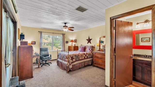 bedroom featuring visible vents, light colored carpet, wood ceiling, and a sink