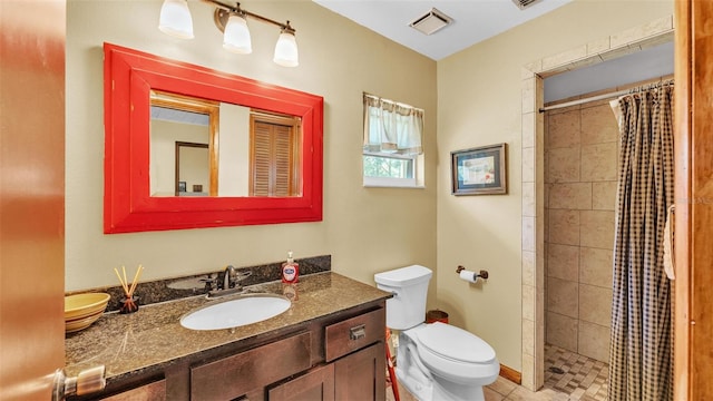 bathroom with visible vents, toilet, vanity, and a tile shower