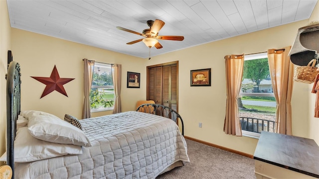 bedroom with a closet, ceiling fan, baseboards, and carpet