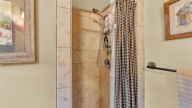 full bath featuring a shower stall and a textured wall