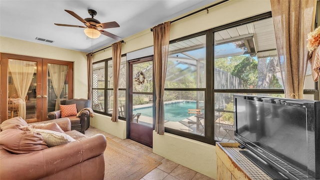 sunroom with visible vents, french doors, and a ceiling fan