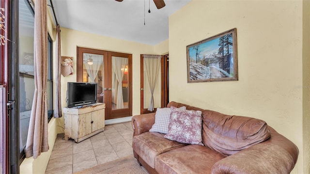 living area with light tile patterned floors, french doors, and a ceiling fan