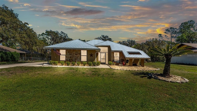 view of front of property featuring a standing seam roof, a front lawn, and metal roof