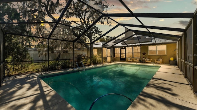 pool at dusk featuring a lanai, a fenced in pool, and a patio