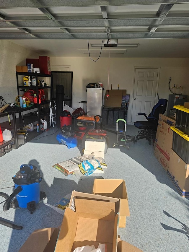 garage featuring a garage door opener and freestanding refrigerator