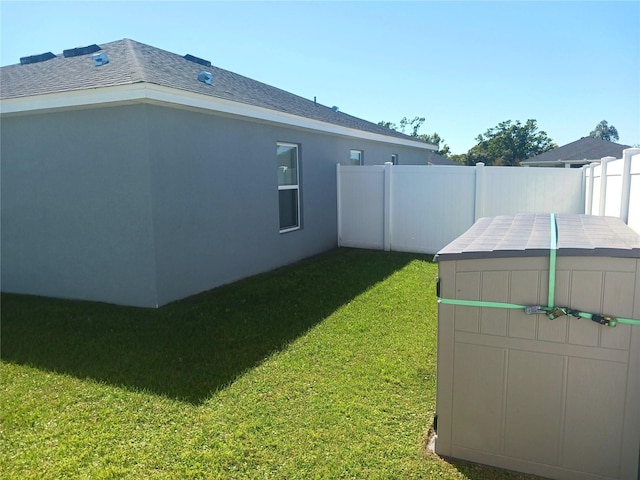 view of yard featuring a storage unit, an outdoor structure, and fence