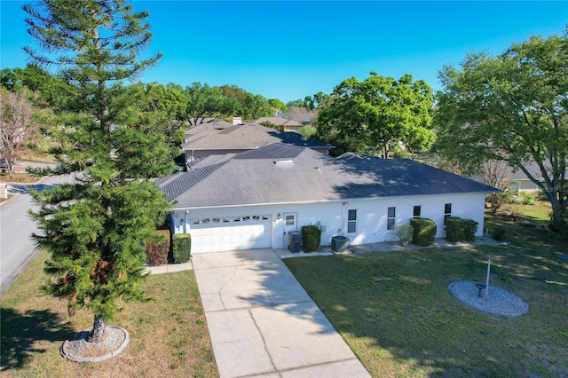 view of front facade featuring roof with shingles, an attached garage, stucco siding, concrete driveway, and a front lawn