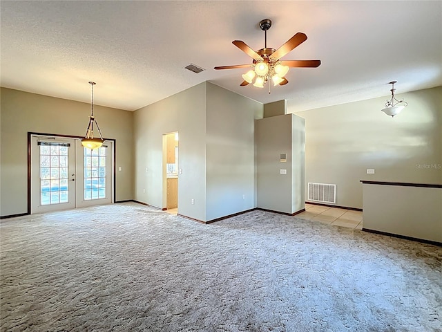 unfurnished room with lofted ceiling, light colored carpet, visible vents, and ceiling fan