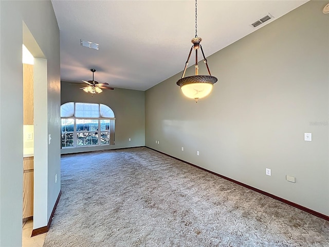 unfurnished room with visible vents, light colored carpet, baseboards, and ceiling fan