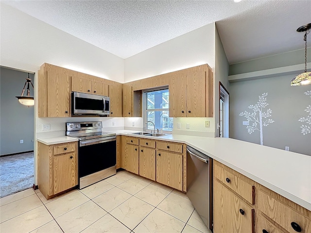 kitchen with pendant lighting, a sink, a textured ceiling, appliances with stainless steel finishes, and light countertops