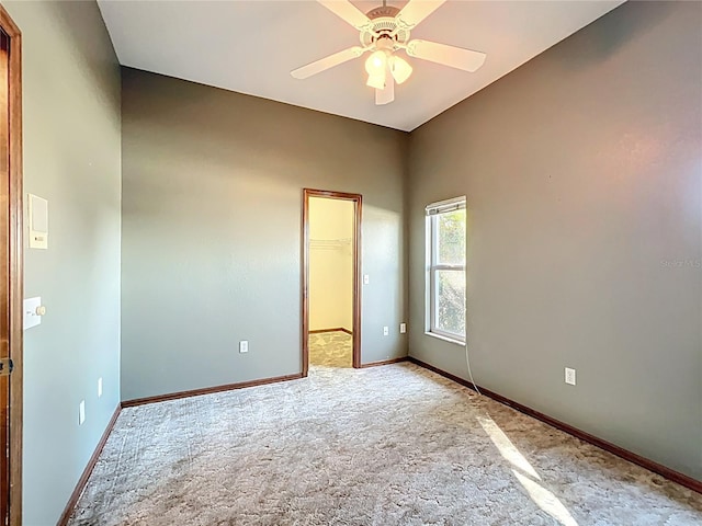 unfurnished room featuring baseboards, light colored carpet, and a ceiling fan