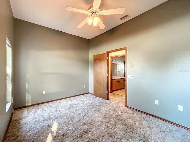 unfurnished room featuring light carpet, visible vents, baseboards, and ceiling fan