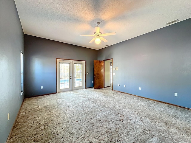 unfurnished room with a ceiling fan, carpet, visible vents, french doors, and a textured ceiling