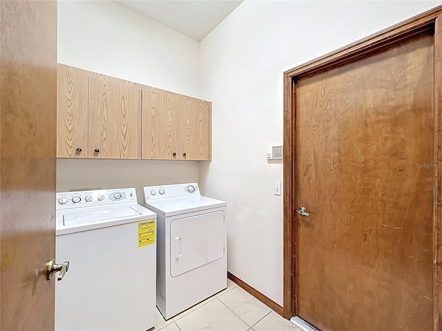 laundry area with washer and dryer, cabinet space, marble finish floor, and baseboards