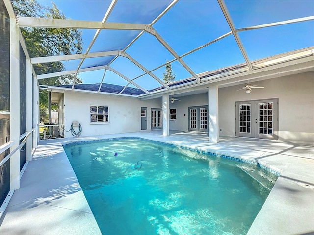 pool with ceiling fan, french doors, glass enclosure, and a patio