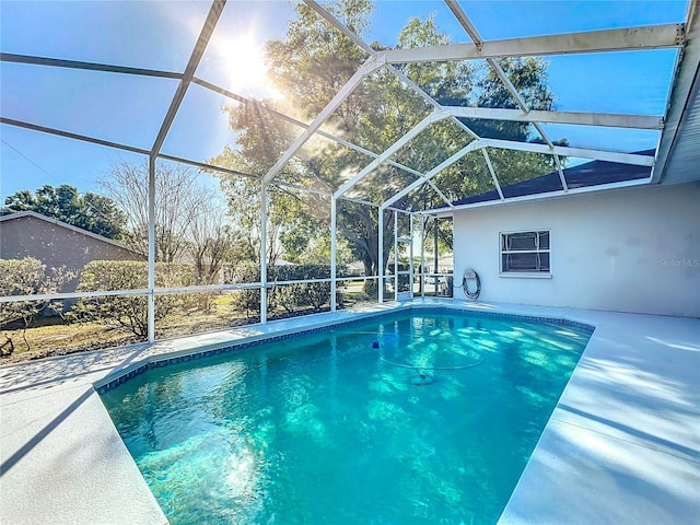 outdoor pool featuring glass enclosure and a patio area