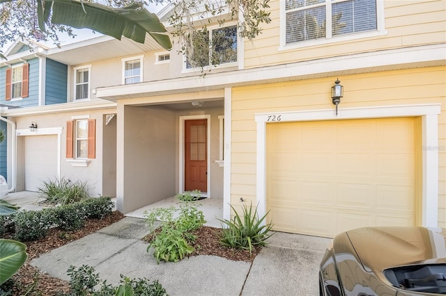 property entrance with stucco siding and an attached garage