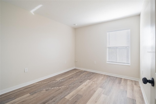 unfurnished room with baseboards and light wood finished floors