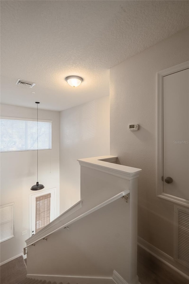 bathroom with visible vents, baseboards, and a textured ceiling