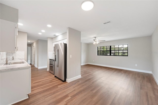 kitchen with a sink, visible vents, white cabinetry, and stainless steel appliances