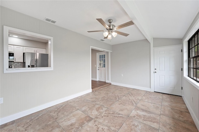 empty room featuring beam ceiling, baseboards, and visible vents