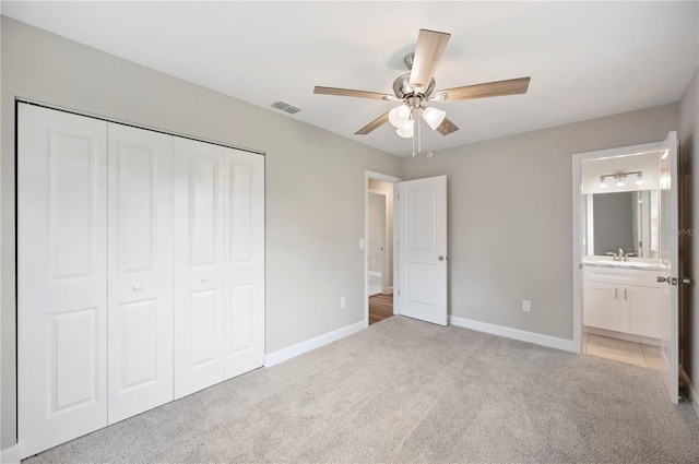 unfurnished bedroom featuring baseboards, visible vents, a closet, light carpet, and connected bathroom