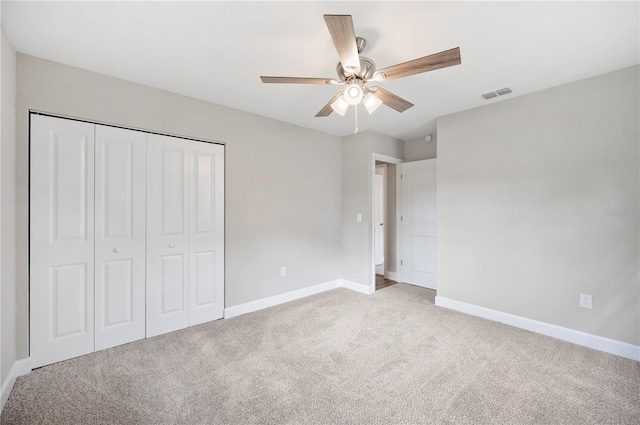 unfurnished bedroom featuring visible vents, ceiling fan, baseboards, light carpet, and a closet