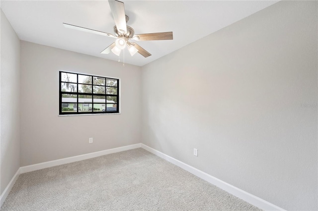 carpeted empty room with ceiling fan and baseboards