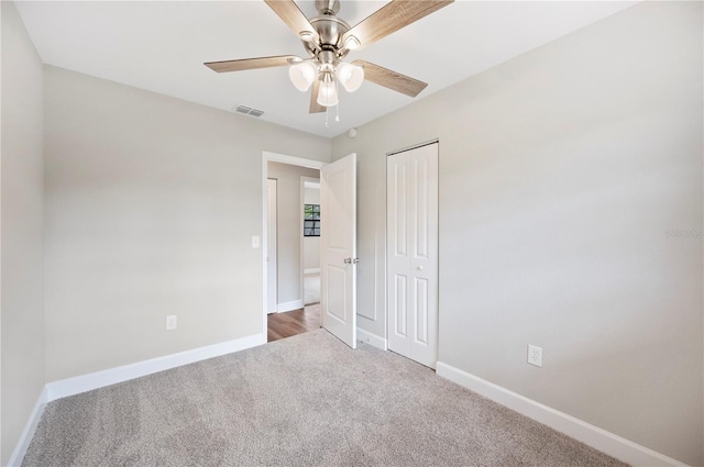 unfurnished bedroom with visible vents, a closet, carpet flooring, baseboards, and ceiling fan