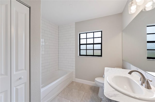 bathroom with baseboards, plenty of natural light, toilet, and vanity