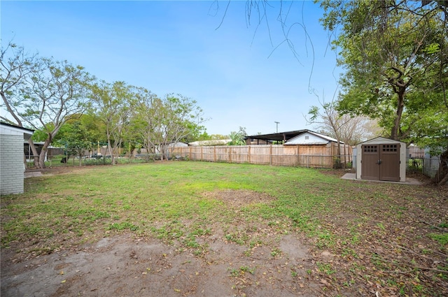 view of yard featuring a storage unit, an outbuilding, and a fenced backyard