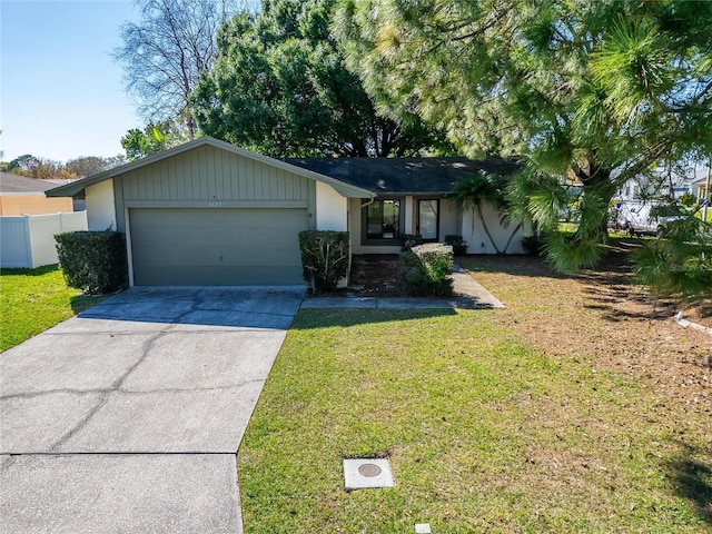 view of front of property featuring driveway, a front lawn, an attached garage, and fence