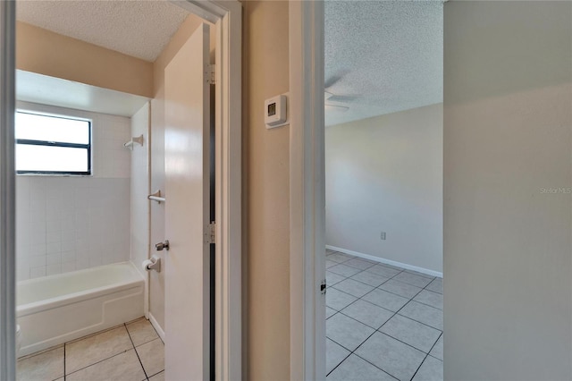 full bathroom featuring tile patterned flooring, a textured ceiling, shower / bath combination, and baseboards