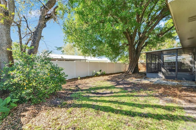 view of yard featuring a fenced backyard and a sunroom