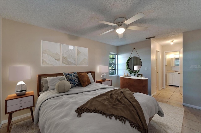 bedroom featuring visible vents, a textured ceiling, light tile patterned floors, baseboards, and ceiling fan