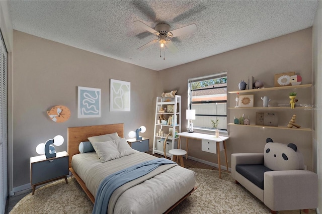 bedroom with baseboards, a textured ceiling, and a ceiling fan