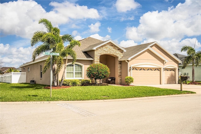 ranch-style house with a front lawn, an attached garage, fence, and stucco siding