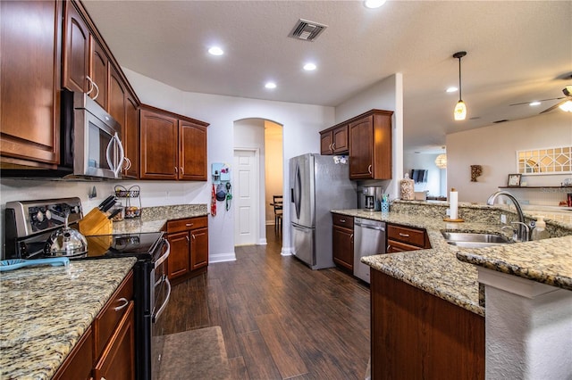 kitchen with visible vents, light stone counters, appliances with stainless steel finishes, arched walkways, and a sink