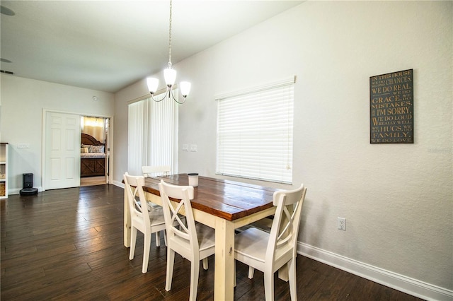 dining room with dark wood finished floors, a notable chandelier, and baseboards