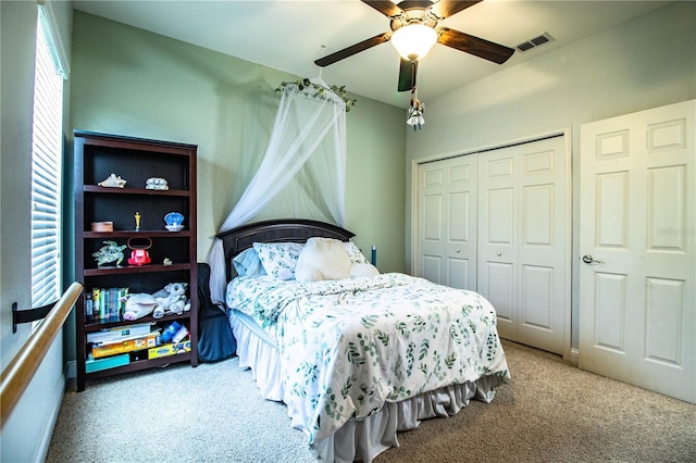 carpeted bedroom with visible vents, a closet, and ceiling fan