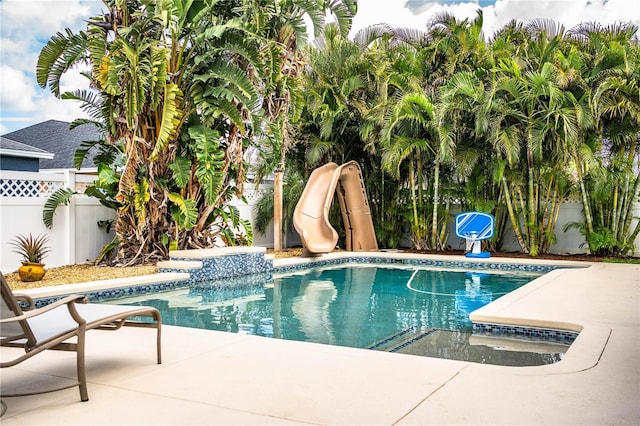 view of swimming pool with a patio area, a fenced backyard, a fenced in pool, and a water slide