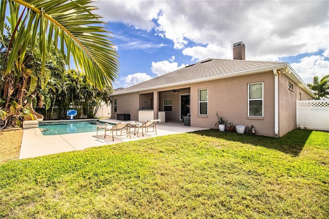 rear view of house with a fenced in pool, fence, stucco siding, a lawn, and a patio area