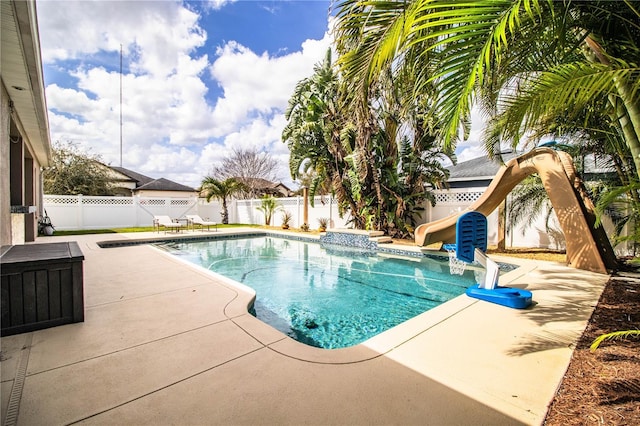 view of pool with a fenced backyard, a fenced in pool, a water slide, and a patio