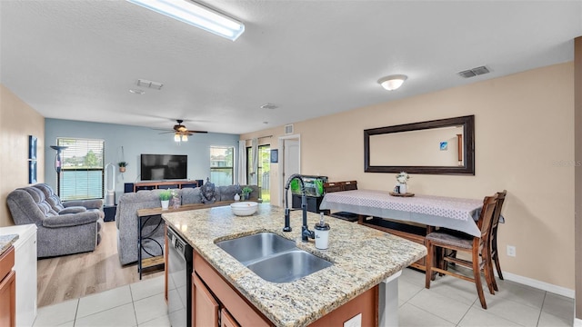 kitchen featuring open floor plan, dishwashing machine, visible vents, and a sink