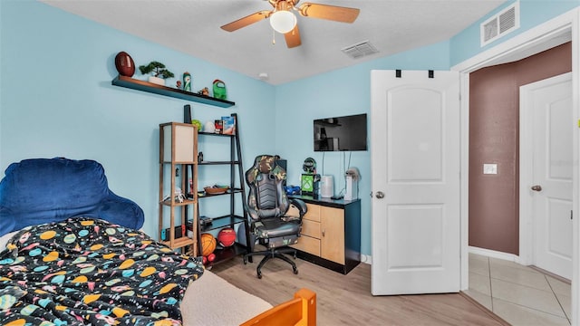 bedroom with visible vents, baseboards, light wood-style floors, and a ceiling fan