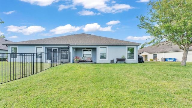 back of property with a yard, stucco siding, and fence