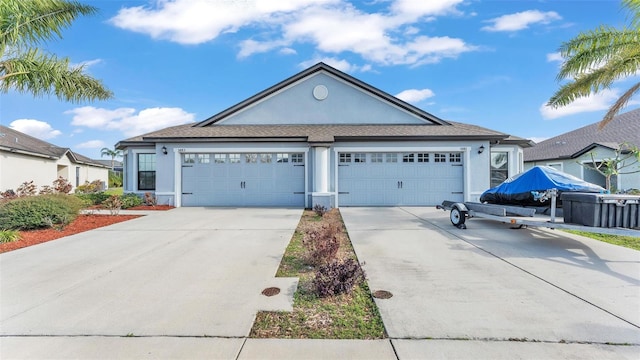 view of front facade with an attached garage, driveway, and stucco siding