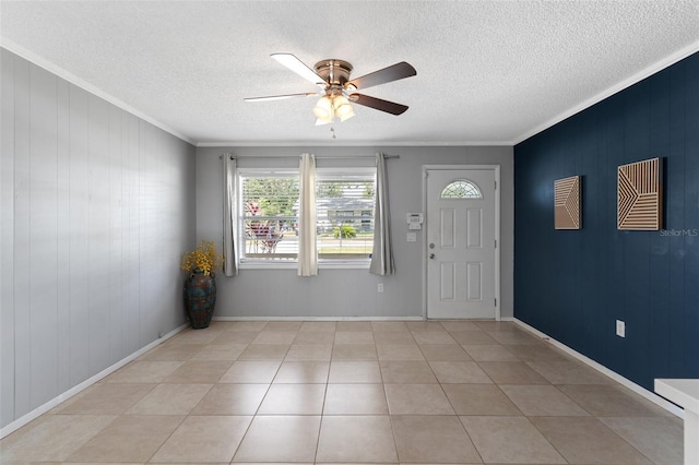 entrance foyer featuring light tile patterned floors, a textured ceiling, a ceiling fan, and ornamental molding