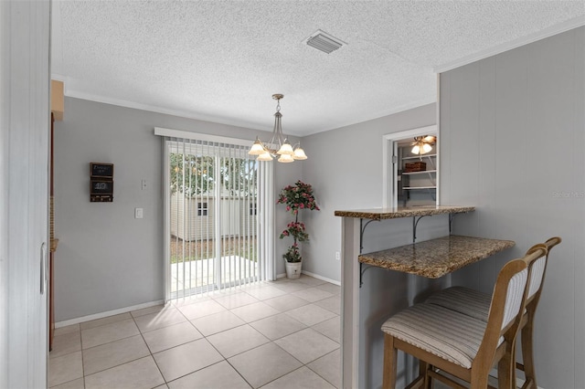 dining area featuring light tile patterned floors, visible vents, a textured ceiling, and an inviting chandelier